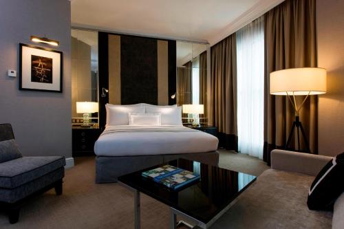 The Ritz-Carlton, Kuala Lumpur في كوالالمبور: غرفه فندقيه بسرير واريكه