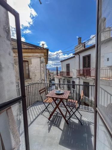 a balcony with a table and a view of a building at Casetta San Giorgio in San Giorgio Lucano
