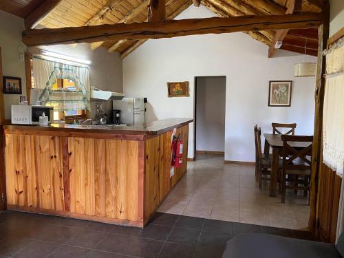 uma cozinha com um balcão de madeira e uma mesa em Cabañas Rukayen em Villa La Angostura