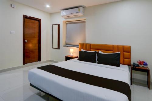 a bedroom with a large bed and a window at Collection O The Cinco Bliss in Hyderabad