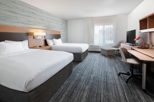 a hotel room with two beds and a desk at TownePlace Suites Oklahoma City Airport in Oklahoma City