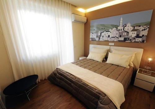 um quarto com uma cama grande e uma janela grande em Interno 9 Matera em Matera