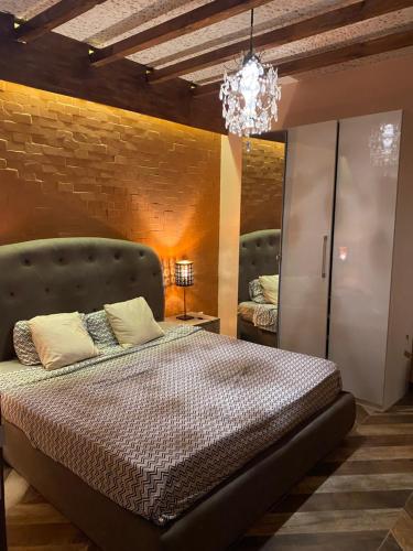 - une chambre avec un lit et un mur en briques dans l'établissement Keur Marieme, à Dakar
