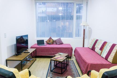 sala de estar con 2 camas y sofá en Gente del Sur - Pacifico en Ushuaia