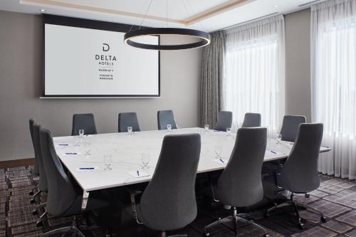 a conference room with a table and chairs and a screen at Delta Hotels by Marriott Toronto Markham in Markham