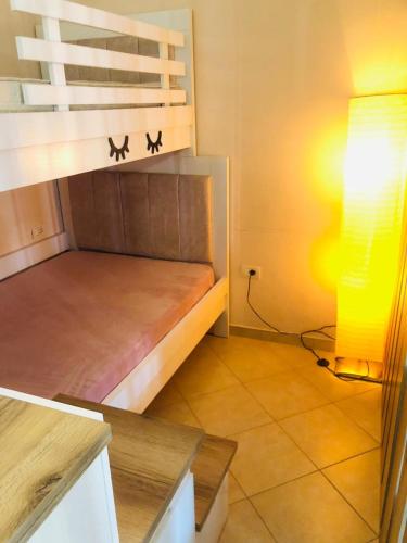 Habitación pequeña con litera y lámpara en Lakeview Cozy Apartment, en Pogradec