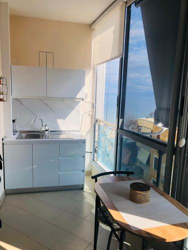 cocina con mesa y ventana grande en Lakeview Cozy Apartment, en Pogradec