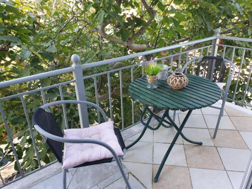 zielony stół i krzesła na balkonie w obiekcie Bei Kostas w mieście Mesopótamon