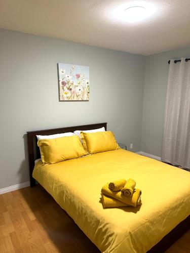 ein Schlafzimmer mit einem Bett mit gelber Bettwäsche und gelben Kissen in der Unterkunft Spacious Downtown 3BR Home, 4bds in Yellowknife