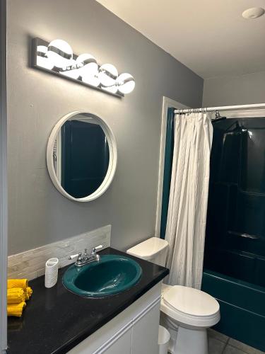 ein Badezimmer mit einem Waschbecken, einem WC und einem Spiegel in der Unterkunft Spacious Downtown 3BR Home, 4bds in Yellowknife