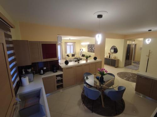 a large kitchen with a glass table and blue chairs at Sunset View in Ioannina