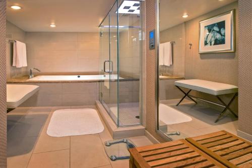 a bathroom with a shower and a tub and a sink at JW Marriott Washington, DC in Washington, D.C.