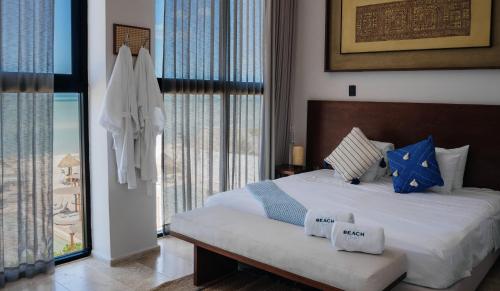 a bedroom with a bed with blue pillows on it at Tótem Beach Club in Celestún