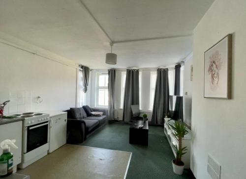 a living room with a couch and a stove at Cozy One Bed Apartment Near Purley Station in Purley