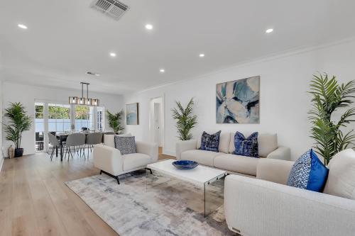 un soggiorno con mobili bianchi e cuscini blu di Gated Villa Blanca 5BR 3BA with Heated Pool & BBQ a Miami