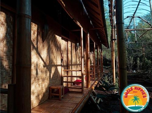 eine Veranda eines Gebäudes mit zwei Stühlen und einem Schild in der Unterkunft Uncle Hippie's Dream in Gili Meno