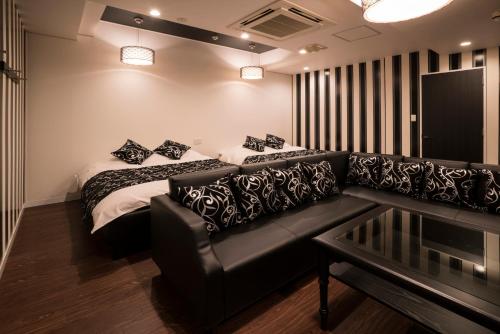 a living room with a couch and a bed at Xenia Amagasaki in Amagasaki