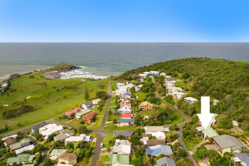an aerial view of a suburb with a white cross on a hill at Barrels Beach House, 28 Dulconghi Street in Crescent Head