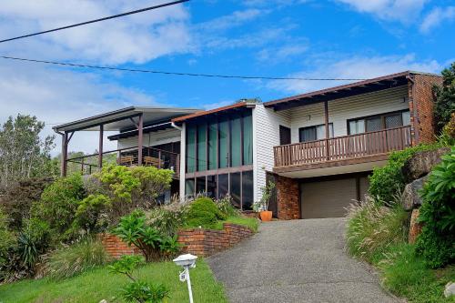 a brick house with a balcony and a driveway at Barrels Beach House, 28 Dulconghi Street in Crescent Head