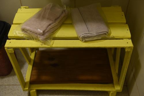 uma prateleira amarela com duas toalhas em Praia de Pajuçara - Kit1 - Castelão Lolla - Maceió em Maceió