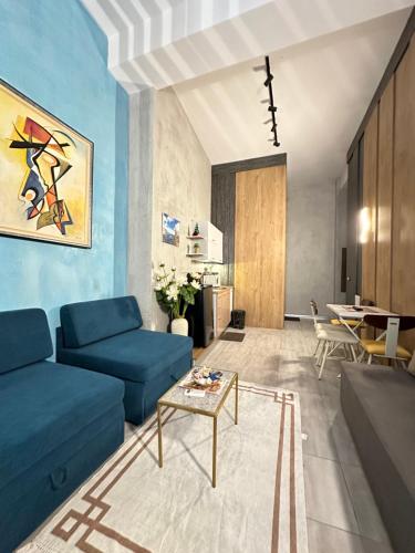 a living room with a blue couch and a table at Colombia Apartments&Rooms in Durrës