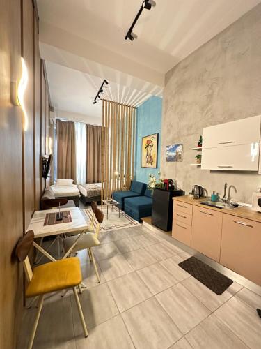 a living room with a blue couch and a kitchen at Colombia Apartments&Rooms in Durrës