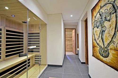 um corredor com uma cabina de duche ao nível do chão e uma pintura na parede em grand chalet LB-3-1 em Saint-Marcel