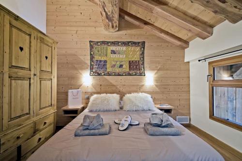 a bedroom with a large bed with shoes on it at grand chalet LB-3-1 in Saint-Marcel