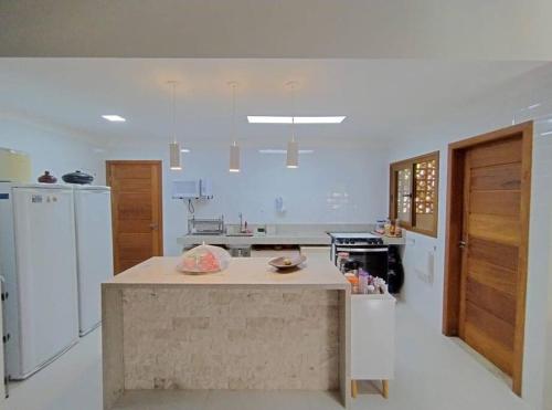 eine große weiße Küche mit einer Insel in der Mitte in der Unterkunft Casa em um ambiente sossegado. in Mata de Sao Joao