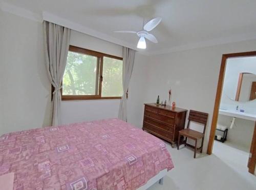 um quarto com uma cama, uma cómoda e uma janela em Casa em um ambiente sossegado. em Mata de São João