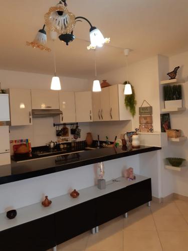 a kitchen with white cabinets and black counter tops at Beralmar in Asilah