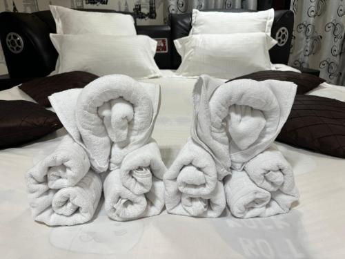 una pila de toallas sentadas encima de una cama en Heaven Apartment, en Predeal