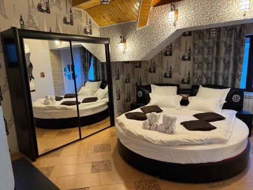 a bedroom with two beds and a large mirror at Heaven Apartment in Predeal