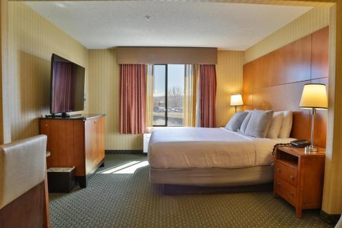 Habitación de hotel con cama grande y ventana en Sweetwater Lodge - Rock Springs - Green River, en Rock Springs