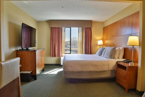 um quarto de hotel com uma cama grande e uma janela em Sweetwater Lodge - Rock Springs - Green River em Rock Springs