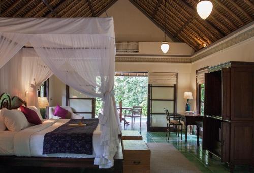 a bedroom with a bed with a canopy at Villa Canggu by Plataran in Canggu