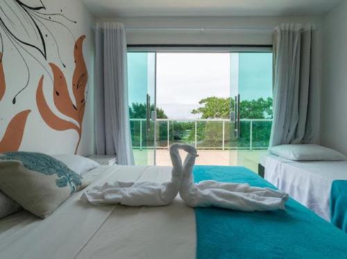 嘎林海斯港Pousada Porto Sol的卧室床上的天鹅雕塑