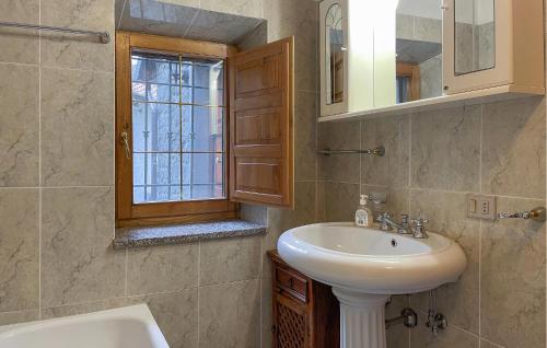 a bathroom with a white sink and a window at Amazing Home In Comano With Kitchenette in Comano