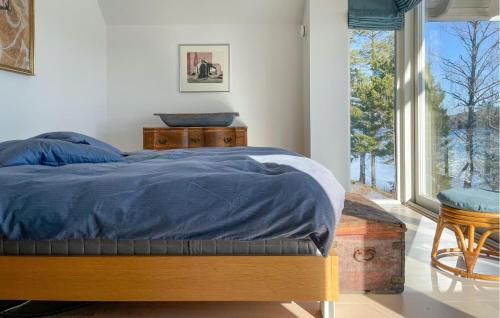 1 dormitorio con 1 cama con edredón azul y ventana en Gorgeous Home In Gustavsfors With Kitchen en Gustavsfors