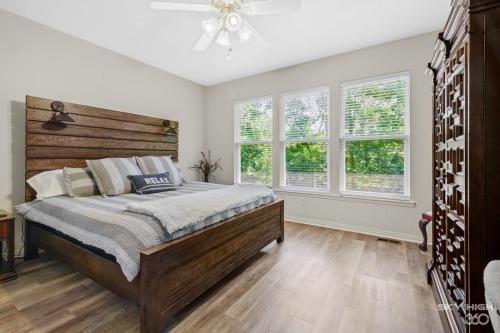 a bedroom with a large bed and two windows at Relaxing BV Home near Golfing, Hiking, & Lakes in Bella Vista