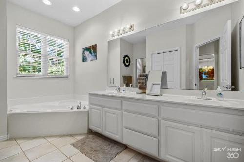 y baño blanco con bañera, lavamanos y bañera. en Relaxing BV Home near Golfing, Hiking, & Lakes, en Bella Vista