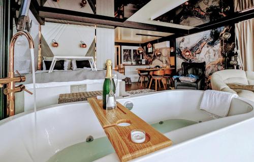 a bath tub with a bottle of champagne sitting on it at Hausboot Hafensuite De Luxe in Sagard