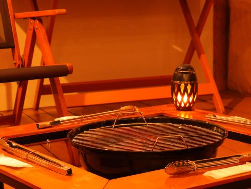 a table with a frying pan and a candle on it at Sloth Glamping in Izumi