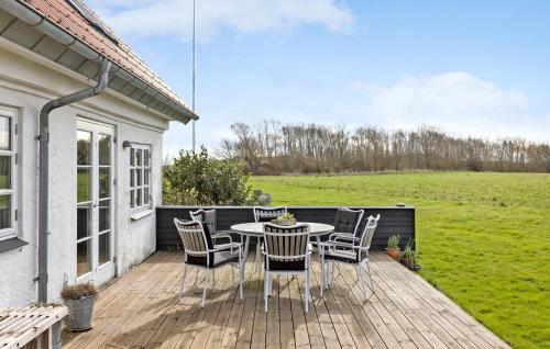 a patio with a table and chairs on a deck at 5 Bedroom Gorgeous Home In Bjørnø in Bjerne