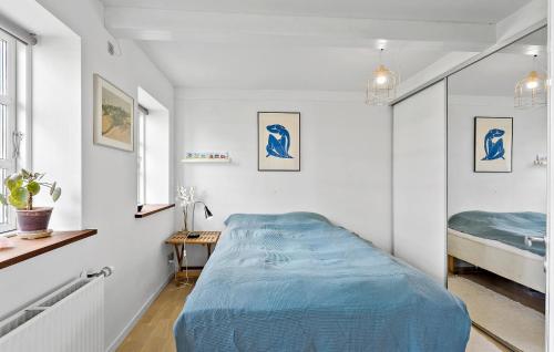 1 dormitorio con 1 cama azul en una habitación blanca en 5 Bedroom Gorgeous Home In Bjrn, en Bjerne