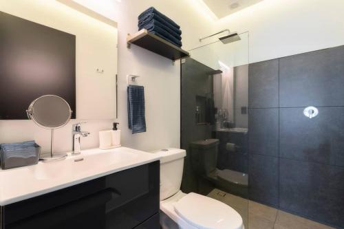 een badkamer met een wastafel, een toilet en een douche bij P302 Zocalo 3bdrm 2bath Rooftop AC in Mexico-Stad