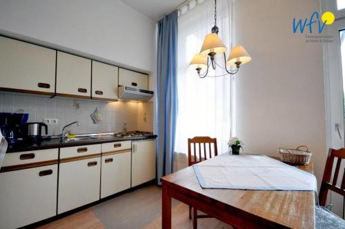 ボルクムにあるKirchstr 11 Borkum Ferienwohnung 11のキッチン(テーブル、ダイニングテーブル付)