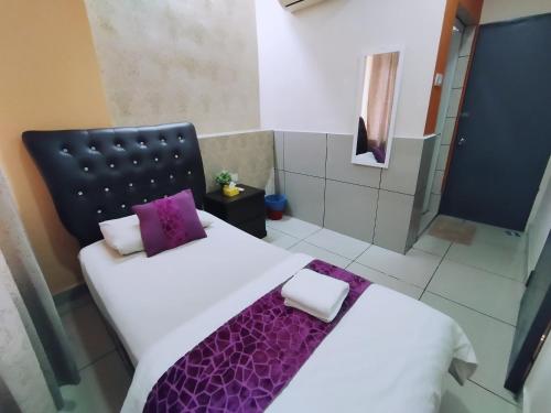 a bedroom with two beds with purple pillows at Mimilala Hotel @ i-City, Shah Alam in Shah Alam