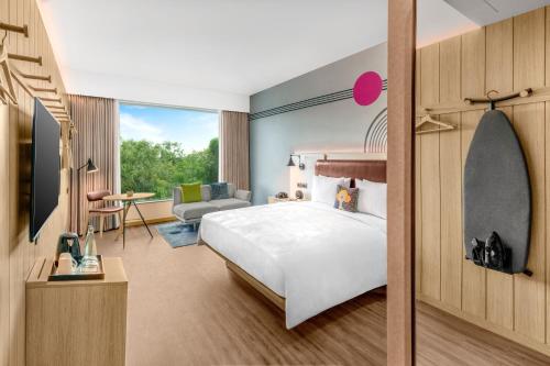 a bedroom with a bed and a living room at Moxy Bengaluru Airport Prestige Tech Cloud in Devanahalli-Bangalore