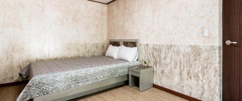 Yoninsan Spring Resort في كابيونغ: غرفة نوم صغيرة مع سرير وطاولة